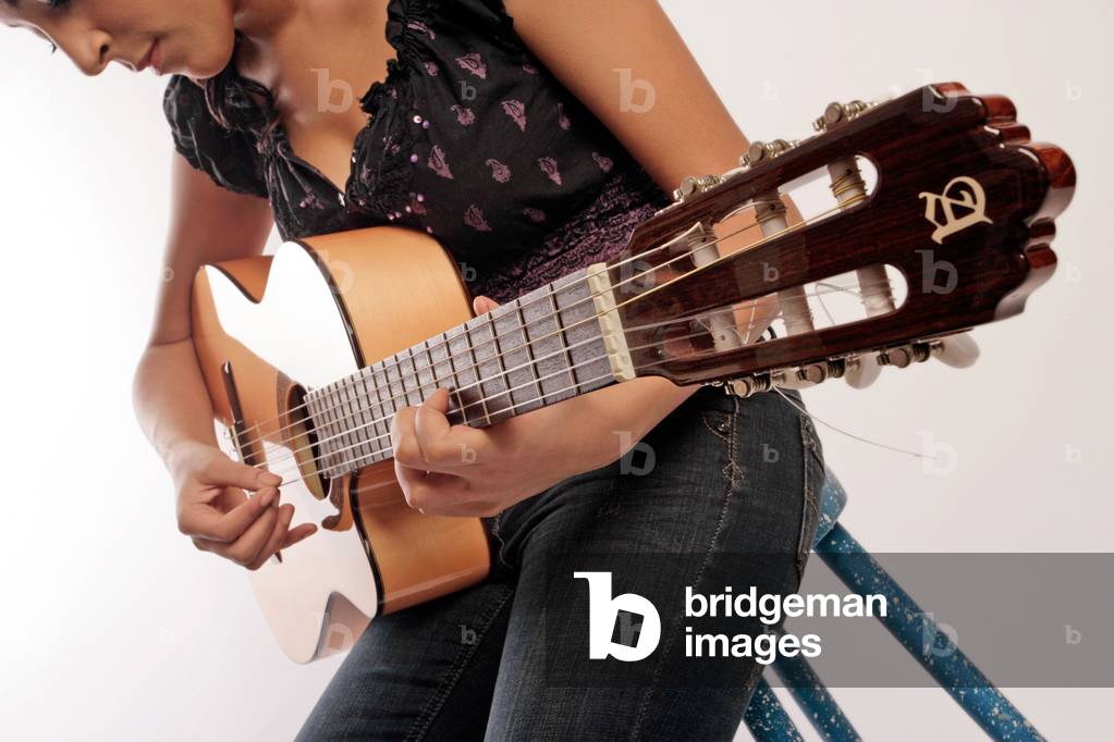 Bild von Fotografie "Junge Frau spielt auf der Akustikgitarre" von Chris Stock