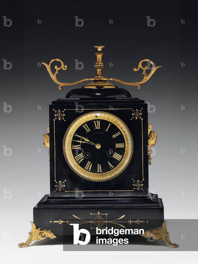 Eine Manteluhr aus schwarzem Kompositionsstein, mit eingeschnittenen Verzierungen, mit Beinen, Endstücken und 