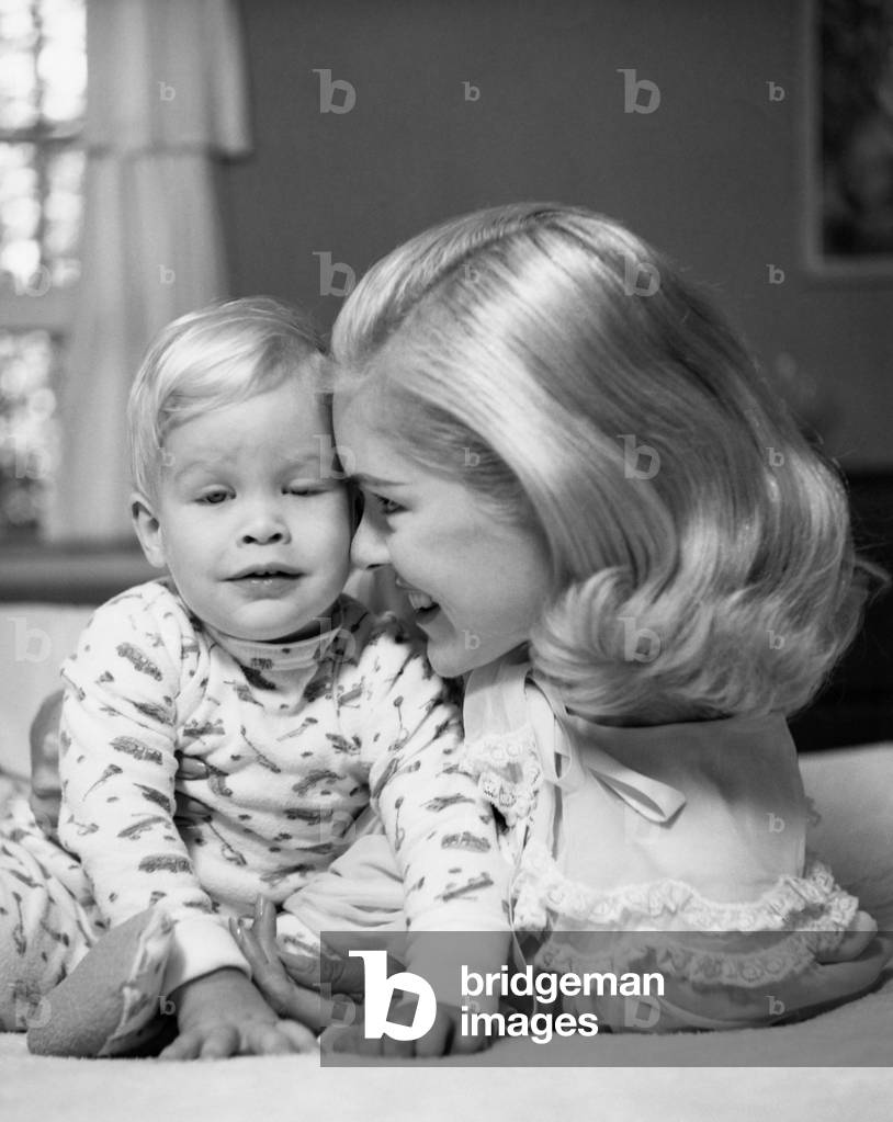 Immagine di Fotografia "Giovane donna con suo figlio sul letto", b/w