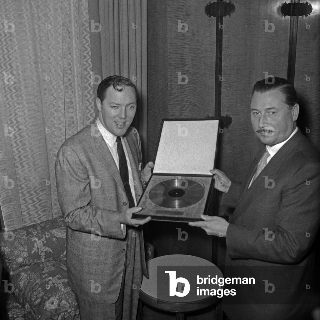 "American Rock n Roll cantante Bill Haley riceve il disco d'oro per la sua canzone «Rock Arount The Clock»", b