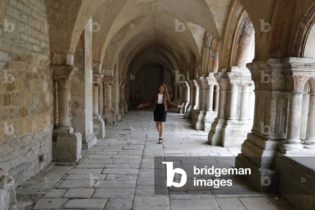 Abbazia cistercense di Fontenay. Una donna che cammina nel chiostro. Francia.