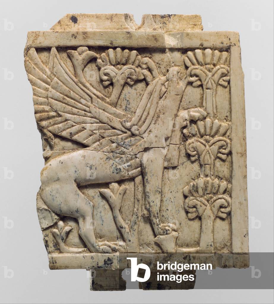 Furniture plaque carved in relief with a griffin in a floral landscape by Neo-Assyrian