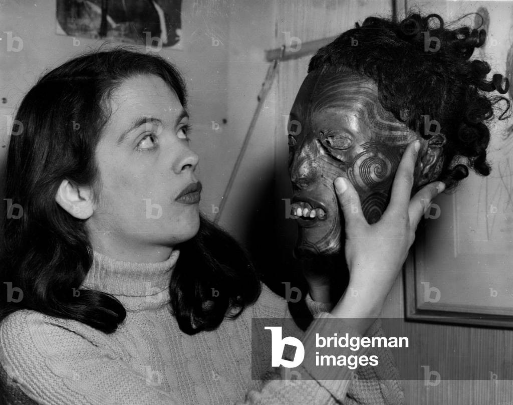 Tue 06, 1953 -” Heads” On Exhibition In London. A Tattooed Maori From New Zealand. An exhibition of” Heads” - is being held at the Institute of Contemporary Arts, Dover Street to illustrate contrasting examples of modern and 18th century art.. Keystone Photo Shows: - Mrs. Terry Hamilton, holding a head - a Tattooed Maori from New Zealand, at the exhibition.