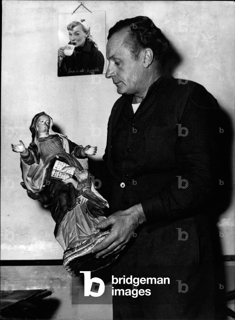 Dec. 12, 1953 - Miracle At Enervaux: Saint's Statute Found Blending: Jean Salvade, who owns a small hotel at Enervaux, 40, miles from nice, holding the” Miracle” statute of Sainte Anne.He Claims the statuette which had a finger broken started bleeding a few days ago.