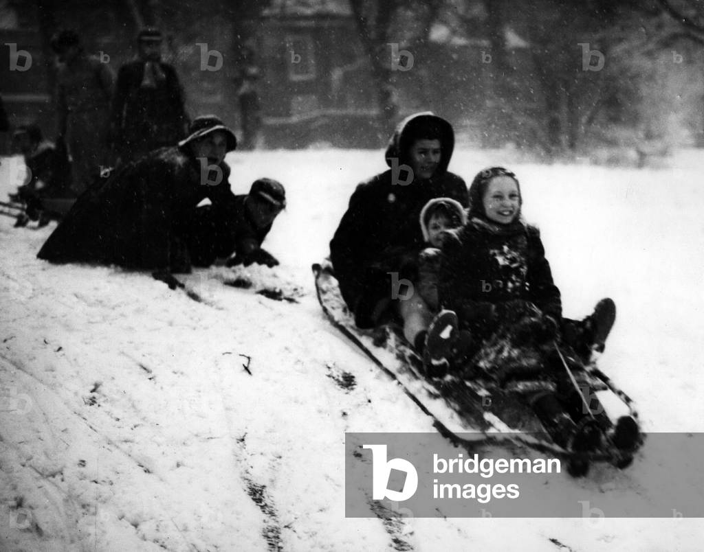 Jan. 01, 1955 - London's first snowfall of the year. Fun for the Tobogganists: Photo shows a good push off for a toboggan load of enthusiasts - during fun in the snow on Hampstead Heath this afternoon