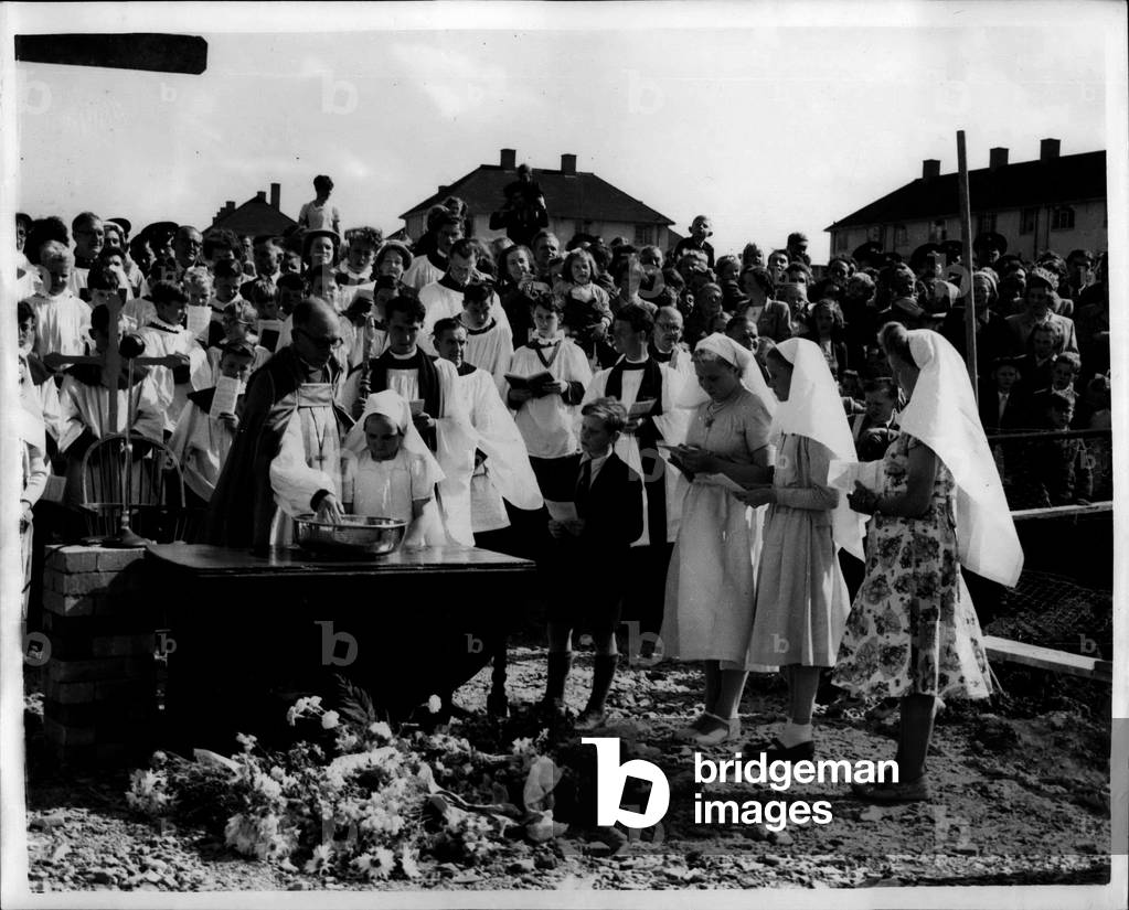Jul. 28, 1953 - Mass Baptim Of Ten Adults And Fifty Babies. After Laying Of Church Foundation Stone In Nottingham. Cut Glass fruit bowls were used as fonts at the mass baptism which followed the laying of the foundation stone of the new Church of St. Francis, on the Clifton Estate, Nottingham, during the wee-end. the stone was laid by the blacksmith of Clifton Village, who is also the Parish Church clerk, and a bricklayer living on the Clifton Estate, Mr.Reuben Simkiss, on of the volunteer workers engaged in building the Church. Ten adults and fifty babies were baptied by the Bishop of Southwell, the RT. F.R. Barry and six other Clergy.. Keystone Photo Shows: - The Bishop of Sothwell baptises the children.