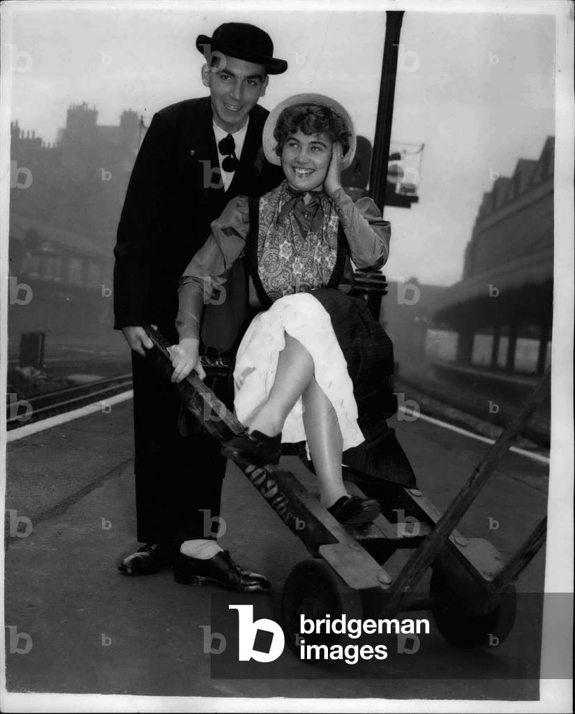 Oct. 10, 1953 - French And Belgian International Dancers Arrive Lady From Leige Gets A 'Lift' From Frenchman: Les Cramingnons Liegeois of Belgium - and Les Dancseurs Chanteurs due Marais Vendeen of France arrived at Victoria Station this morning. They Went to the Royal Albert Hall - where they are taking party in the International Dance Festival