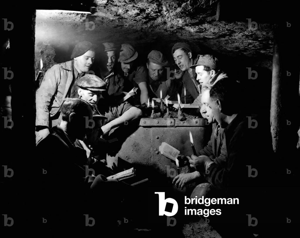 Dec. 12, 1954 - CHRISTMAS CAROL SERVICE - 200 FEET BROW GROUND.. MINERS WAIT.. The Rev. R.N. Timms yesterday held a Christmas Carol Service for Miners - 200 feet below ground at the Furnace Pit, Lower Gornal, Dudley, Worcestershire.. Keystone Photo Shows: - Scene during the Pit Carol Service - with on right the Rev. R.N. Timms assisted by the Rev. G. Hunt (left) the Local Methodist Minister