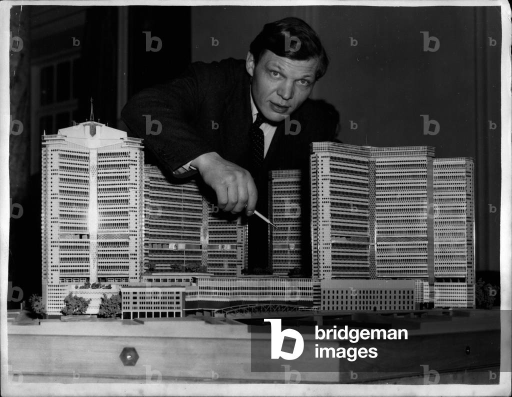 Standing beside a plastic model of his dream, MR. Sergei Kadieigh, architect and a postle of building” up” a poke yesterday of life in” High Paddington” 1953 (b/w photo)